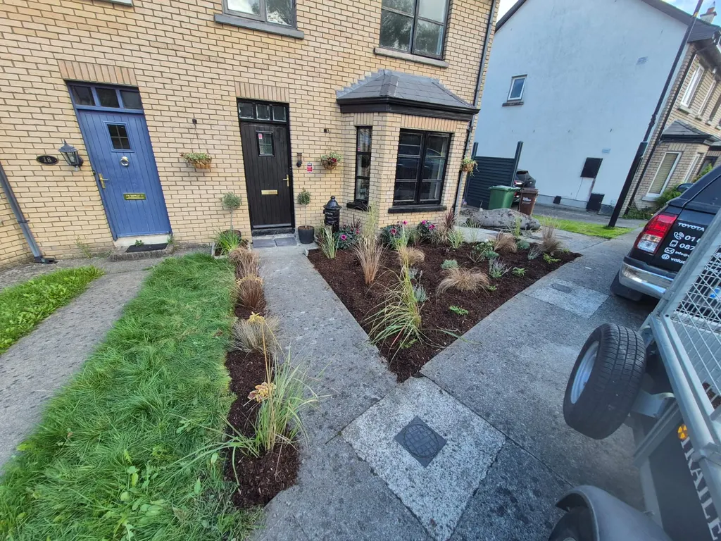 Two new front garden beds of ornamental grasses either side of a path